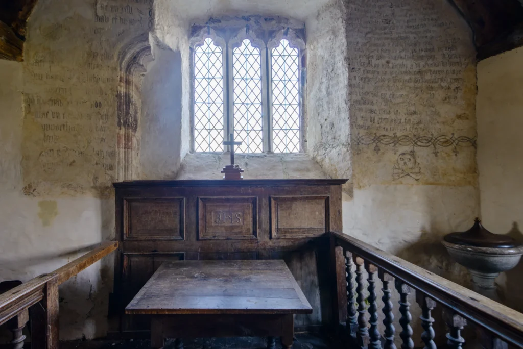 The altar wall. The Ten Commandments and the Lord's Prayer, both in Welsh, painted on lime-washed stone above the altar.