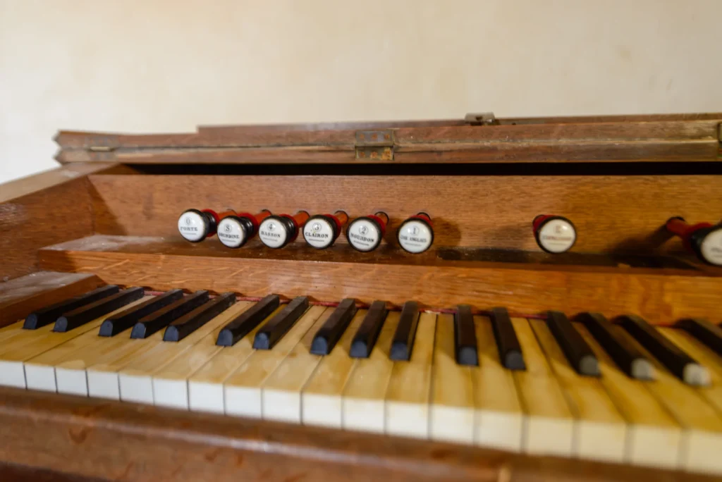 Worn black and white keys of an old pedal organ.