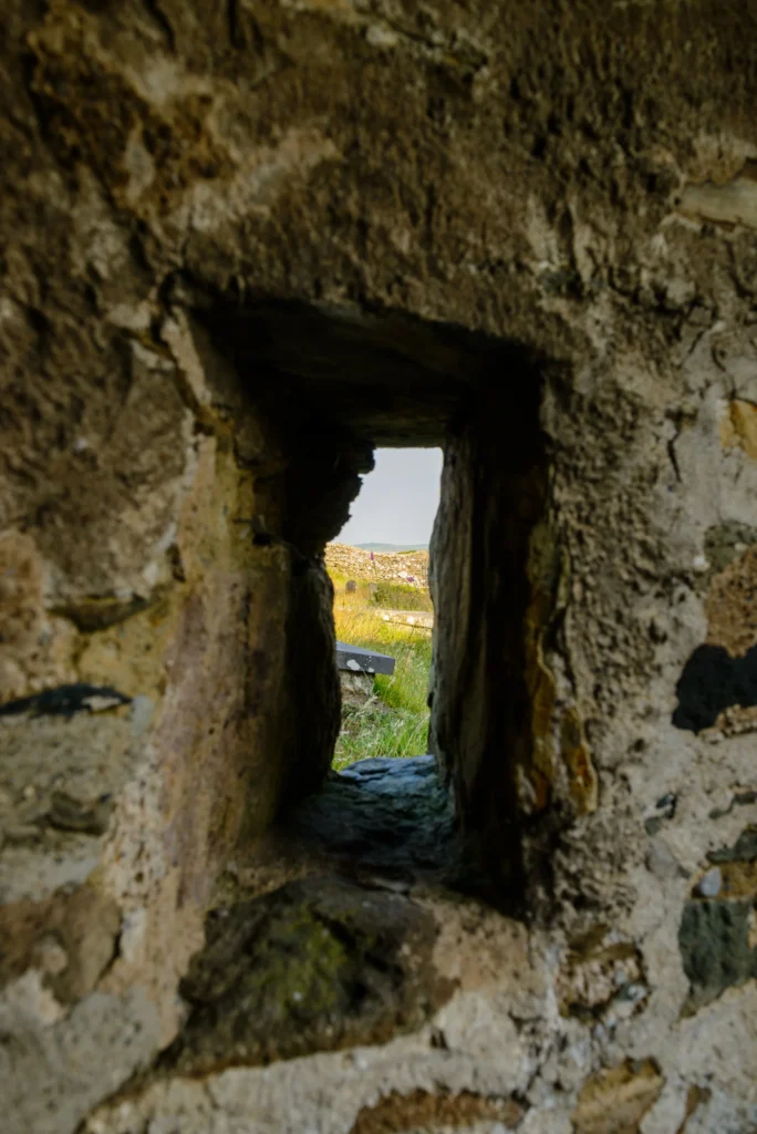 The hagioscope in the south porch – a narrow angled aperture through the stone wall with a sightline to the churchyard gate.